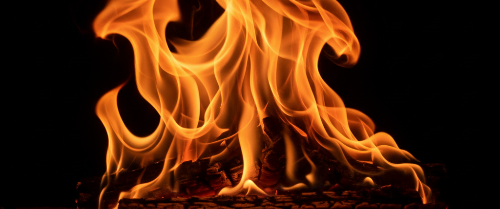 Vibrant orange and yellow flames dancing upward against a solid black background.